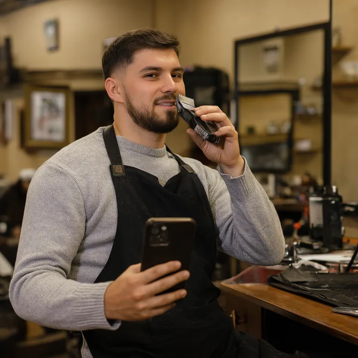 Barber checking new reviews between haircuts