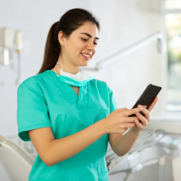 Dentist reading a fresh patient review on her phone